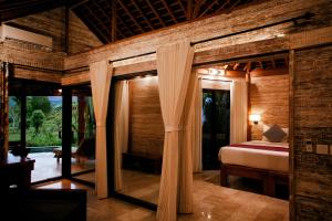 a bedroom with a bed and a large glass doorway at Sunrise Paradise Bali in Karangasem