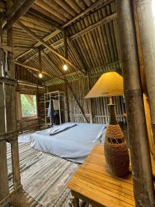 a bedroom with a bed and a table with a lamp at Con Dao Backpacker - LoCo Camping in Con Dao