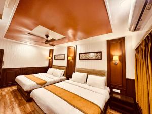 Habitación de hotel con 3 camas y techo en Walisons Hotel, en Srinagar
