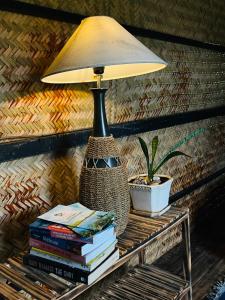 a lamp sitting on top of a table with books at Con Dao Backpacker - LoCo Camping in Con Dao