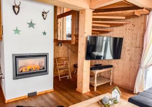 a living room with a fireplace and a tv at 1A Chalet "Wolke" Ski und Wellness im Traumhaus in Wolfsberg