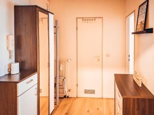 a kitchen with a white door and a wooden floor at Weideglück-Zentral-Dampfdusche in Oberstaufen