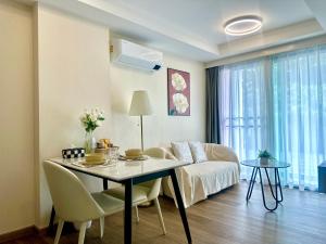 a living room with a table and a couch at 3 Min Walk to Central Festival, Infinity Pool, 1 bedroom 1 bathroom in Chiang Mai