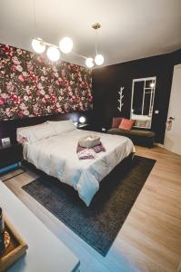 - une chambre avec un grand lit orné d'un mur fleuri dans l'établissement Artists' Nest, à Marsaskala