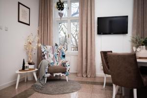 uma sala de estar com uma cadeira e uma janela em Apartment HYGGE em Subotica