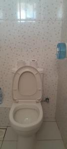 Un baño con un inodoro con el asiento levantado en Hotel Manas Mtwapa Mombasa, en Mtwapa