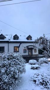 una casa blanca con nieve en el suelo en Jager Guesthouse, en Sopron