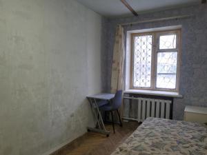 een slaapkamer met een bed, een bureau en een raam bij Peace avenue in Kiev
