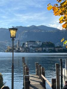 a street light sitting on a dock next to a body of water at Residenza San Rocco ''Suite sul lago'' in Orta San Giulio