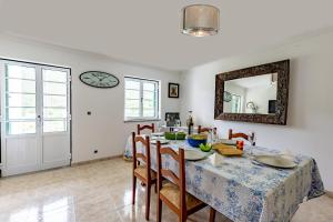 a dining room with a table and a clock on the wall at A Casa da Rapariga de Cabelo Azul in Manteigas