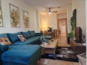 a living room with a blue couch and a table at La casa del patio in Zafra