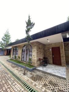 a brick building with a tree in the courtyard at La Berza Resort in Subang