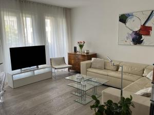 a living room with a couch and a tv at Luxury 2-Bedroom Flat close to FAIR & OLD TOWN in Düsseldorf