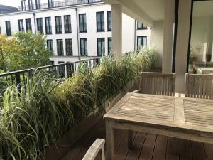 balkon z drewnianym stołem i roślinami w obiekcie Luxury 2-Bedroom Flat close to FAIR & OLD TOWN w mieście Düsseldorf