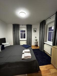 a bedroom with a large bed and two windows at Apartament nad rzeką in Kowary