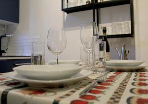 uma mesa com pratos e copos de vinho numa mesa em Industrial Design Loft near City Center and Stadium em Bolonha