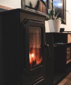 a wood stove with a fire in it at Tiny House Au Coeur de la Campagne Wallonne in Chaumont-Gistoux