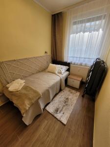 a small bedroom with a bed and a window at Mádi Rezidencia in Budapest