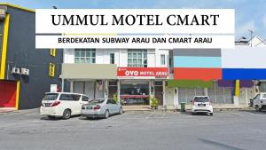 a group of cars parked in a parking lot in front of a building at UMMUL MOTEL CMART in Arau