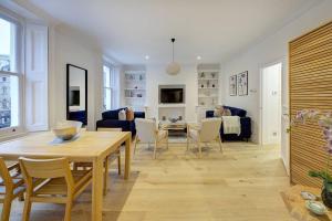 - un salon avec une table et une salle à manger dans l'établissement Stunning Hyde Park Apartment, à Londres