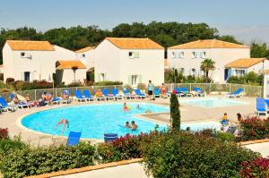 un grupo de personas en la piscina de un complejo en Résidence Goélia La Palmeraie, en Saint-Georges-dʼOléron