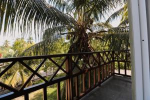 uma vista para uma palmeira a partir de uma varanda em Coop Safari Hotel em Tissamaharama