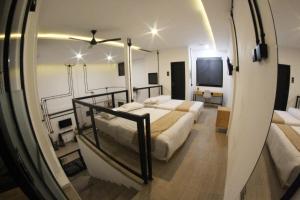 1 dormitorio con 2 camas y espejo en KLAB House - Guest House, en Yogyakarta