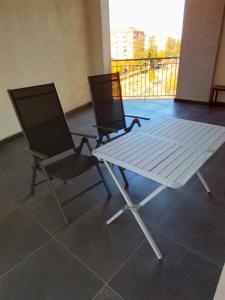 two chairs and a white table on a balcony at Uniclub House in Cosenza