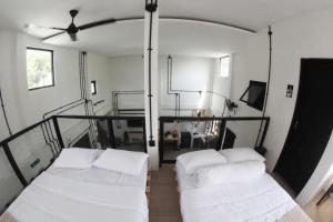 Habitación con 2 camas blancas y ventilador de techo. en KLAB House - Guest House, en Yogyakarta