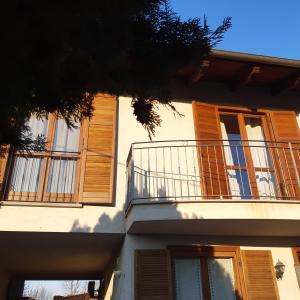 ein Gebäude mit Holzfenstern und einem Balkon in der Unterkunft Casa Olimpia in Priocca