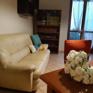 ein Wohnzimmer mit einem Sofa und einem Tisch in der Unterkunft Casa Olimpia in Priocca