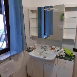 ein Bad mit einem Waschbecken und einem Spiegel in der Unterkunft Casa Olimpia in Priocca
