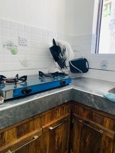 a kitchen counter with a blue stove top oven at Moraa’s Home in Mombasa