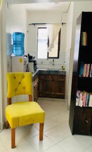 a yellow chair in a kitchen with a sink at Moraa’s Home in Mombasa