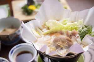 Ichimaru Ryokan - Vacation STAY 35990v في Tenkawa: وعاء من الطعام مع المأكولات البحرية والخس على الطاولة