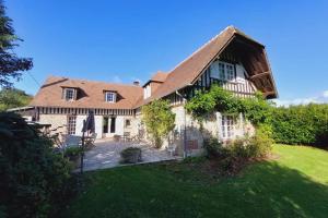 ein großes Haus mit grünem Rasen davor in der Unterkunft Maddalena - Charming country villa for 10 people in Barneville-la-Bertrand