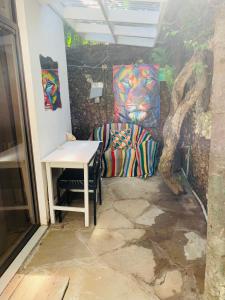 Moraa’s Home في مومباسا: غرفة بطاولة وكرسي بجانب شجرة