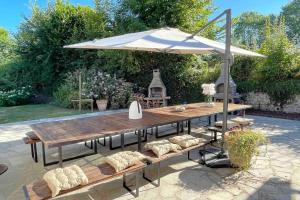 a picnic table with an umbrella and chairs at Maddalena - Charming country villa for 10 people in Barneville-la-Bertrand