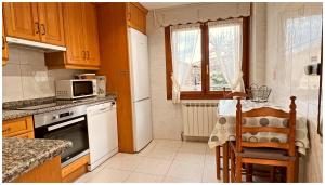 uma cozinha com um frigorífico branco e um micro-ondas em Casa Rural Xixa Landetxea em Miranda de Arga