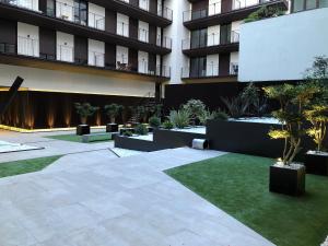 a courtyard of an apartment building with a lawn at Apartamenticos Plaza del Pilar I in Zaragoza