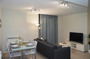 uma sala de estar com um sofá e uma mesa em Apartamenticos Plaza del Pilar I em Saragoça