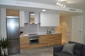 uma cozinha com armários brancos e um forno com placa de fogão em Apartamenticos Plaza del Pilar I em Saragoça