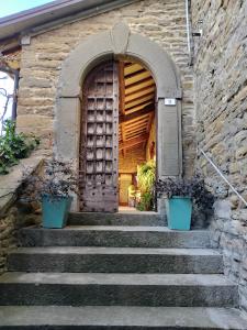 un conjunto de escaleras que conducen a una puerta de madera en #FortCozzo - JacuzziSuite & Sauna - Casola Valsenio, en Mercatale