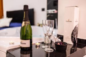 a bottle of champagne and a wine glass on a counter at SUITE CELESTIA CASORIA By Suite in Casoria