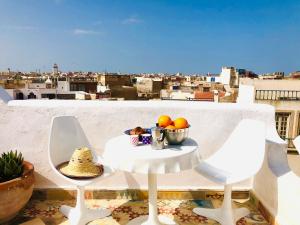a table with a bowl of fruit on a balcony at Dar 91 Essaouira in Essaouira