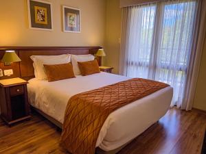 um quarto com uma cama grande e uma janela em Hotel Recanto da Serra em Gramado