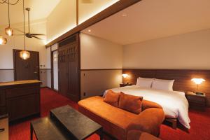 京都市にある丸福樓のベッドとソファ付きのホテルルーム