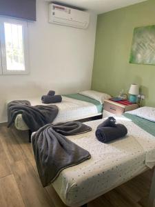 a room with three beds with towels on them at Casa Hombre Blanco in Málaga