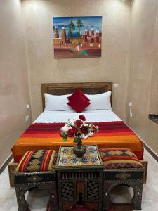 a bedroom with a bed with a vase on a table at Riad Alice Terrace & Spa in Marrakech