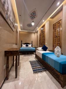 a bedroom with two beds and a desk in it at Riad Alice Terrace & Spa in Marrakesh